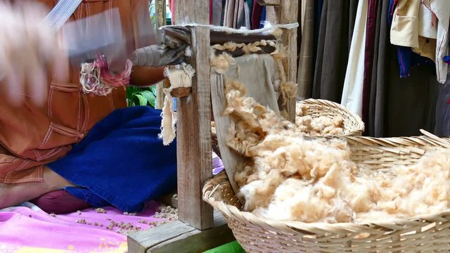 artisan man demonstrating how to make cotton thread