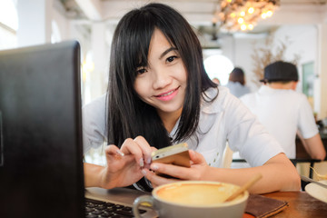 Asian hipster businesswoman working on laptop with cup of coffee