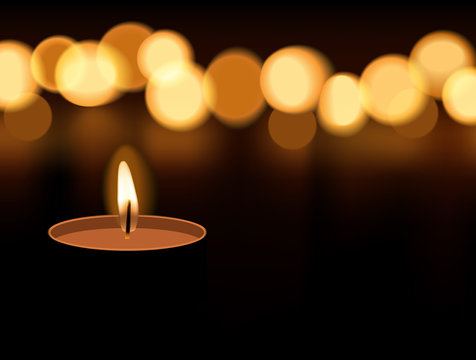 Candle light burning with candle flame bokeh on dark background