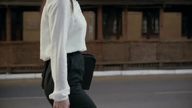 Young businesswoman walking in old city. slow mo