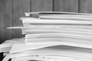 Stack of business report paper files on desk