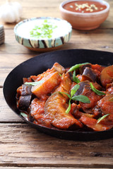melanzane cucinate con pomodoro e spezie sfondo rustico