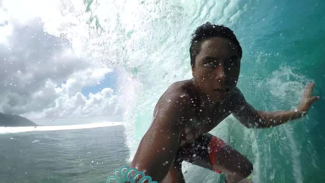 SLOW MOTION: Pro surfer surfing big tube wave and falls