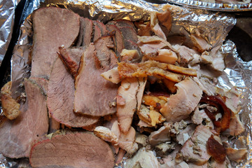 Slices of cooked Beef and Pork laying on tin foil ready to be served for dinner