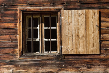 Obraz na płótnie Canvas Window of a wooden alpine hut. Rustic background.