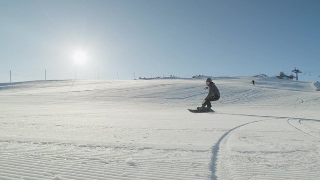 SLOW MOTION CLOSEUP: Snowboarder carving on perfect snow in morning