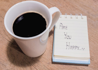 White Cup of coffee and litter notebook with word 