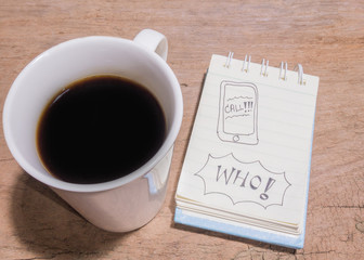 White Cup of coffee and litter notebook with word 