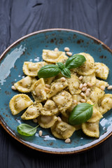 Closeup of ravioli served with basil pesto and pine nuts