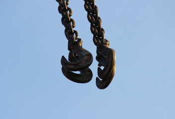 hook and boom lifting machinery at a construction site on sky background