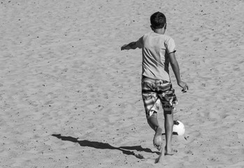 Menino chutando a bola.