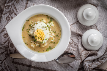 Sorrel soup with egg in white bowl.
