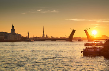 Naklejka premium Russia, Saint-Petersburg, 03 July 2016: Closing of Palace Bridge at sunrise, the Peter and Paul Fortress Spike in the orange sky, Rostral colomn, ships, boats, the traffic beginning, sun, 