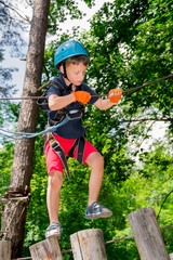 Naklejka na ściany i meble Five year boy on rope-way in forest