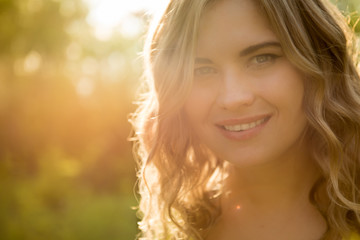 face of a beautiful girl in the setting sun