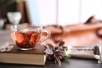 Cup of tea with book on brown table