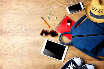 Naklejka premium Backpack with accessories on wooden floor