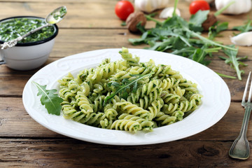 pasta corta fusilli con pesto di rucola sfondo rustico