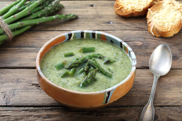 zuppa vellutata di asparagi sfondo tavolo legno rustico