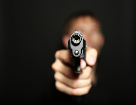 Man with gun on black background