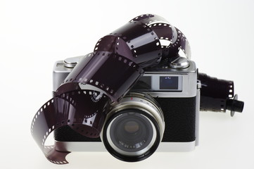 Old rangefinder analog camera system 135 and the photographic film on the white background.