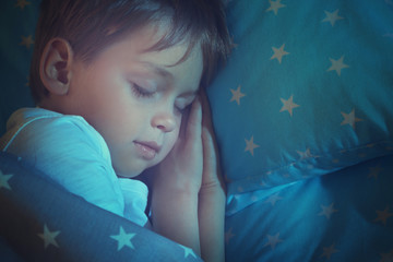 Adorable little boy sleeping in bed, close up
