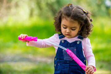 Portrait of cute girl blowing soap bubbles