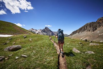 Obraz premium a young woman hiking with a backpack in the mountains