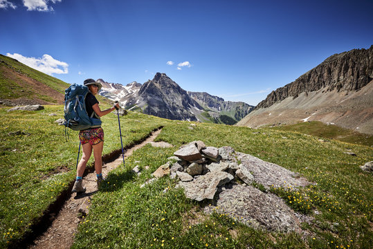 a young woman hiking with a backpack in the mountains