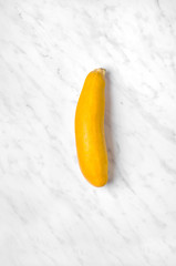 Yellow zucchini on the marble table - obrazy, fototapety, plakaty