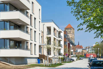Moderne Wohnhäuser mit Kirche im Hintergrund