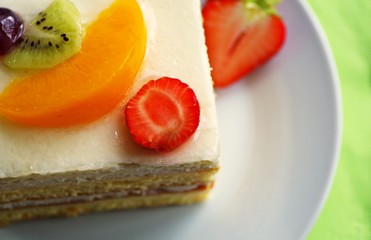 Delicious sweets white cream cake with kiwi, strawberry and peach. Taste fruity cake desserts.