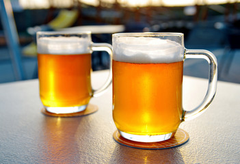 Two beers on the table, outdoor space in the background