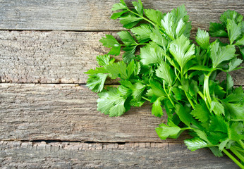 fresh celery leafs on wooden surface