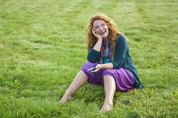 woman talking on phone top of the grass