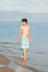 young boy playing on a sandy beach on a summer day