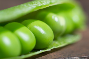 Big fresh green pea pod closeup. Shallow depth of field