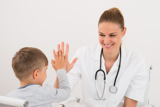 Doctor Giving High Five To Boy