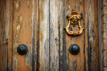 Fototapeta premium Doorknob on an old wooden door. Tuscany, Italy