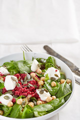salad with beet and cheese served in a white bowl