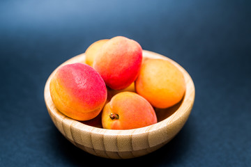 Fresh Apricots in a bowl on a dark background