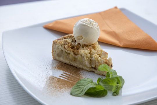 Apple pie dessert decorated with vanilla, mint and cinnamon .