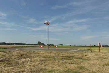Red and white windsock wind filled blue sky background