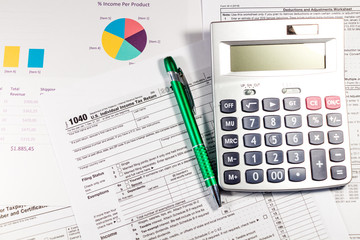 Calculating numbers for income tax return with pen and calculator