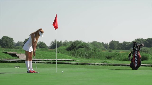 Woman prepares for the putting at the golf