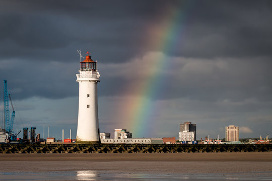Perch Rock lighthouse at New Brighton near Liverpool with dark clouds and a rainbow