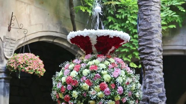 Feast of Corpus Christi. Egg on jet of water in the fountains decorated with flowers at gothic district of Barcelona
 
