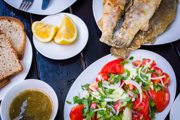 fried fish with fresh herbs and lemon