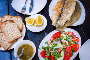 fried fish with fresh herbs and lemon