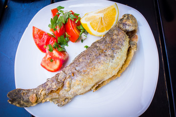 fried fish with fresh herbs and lemon